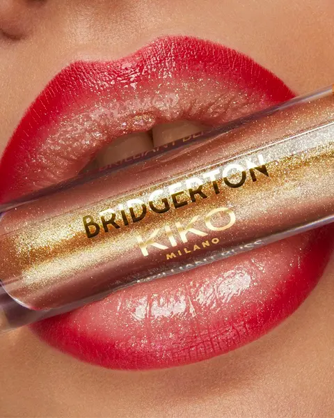 Lábios com o gloss Kiko Brilliant Bliss Lip Gloss 01 Gilded Gaze, com acabamento dourado e brilhante.