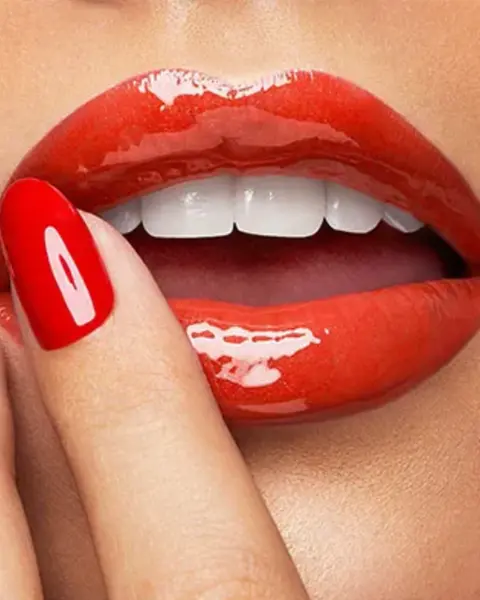 Gloss Kiko 105 Fire Red aplicado nos lábios, criando um acabamento cremoso e vibrante de cor vermelha intensa.